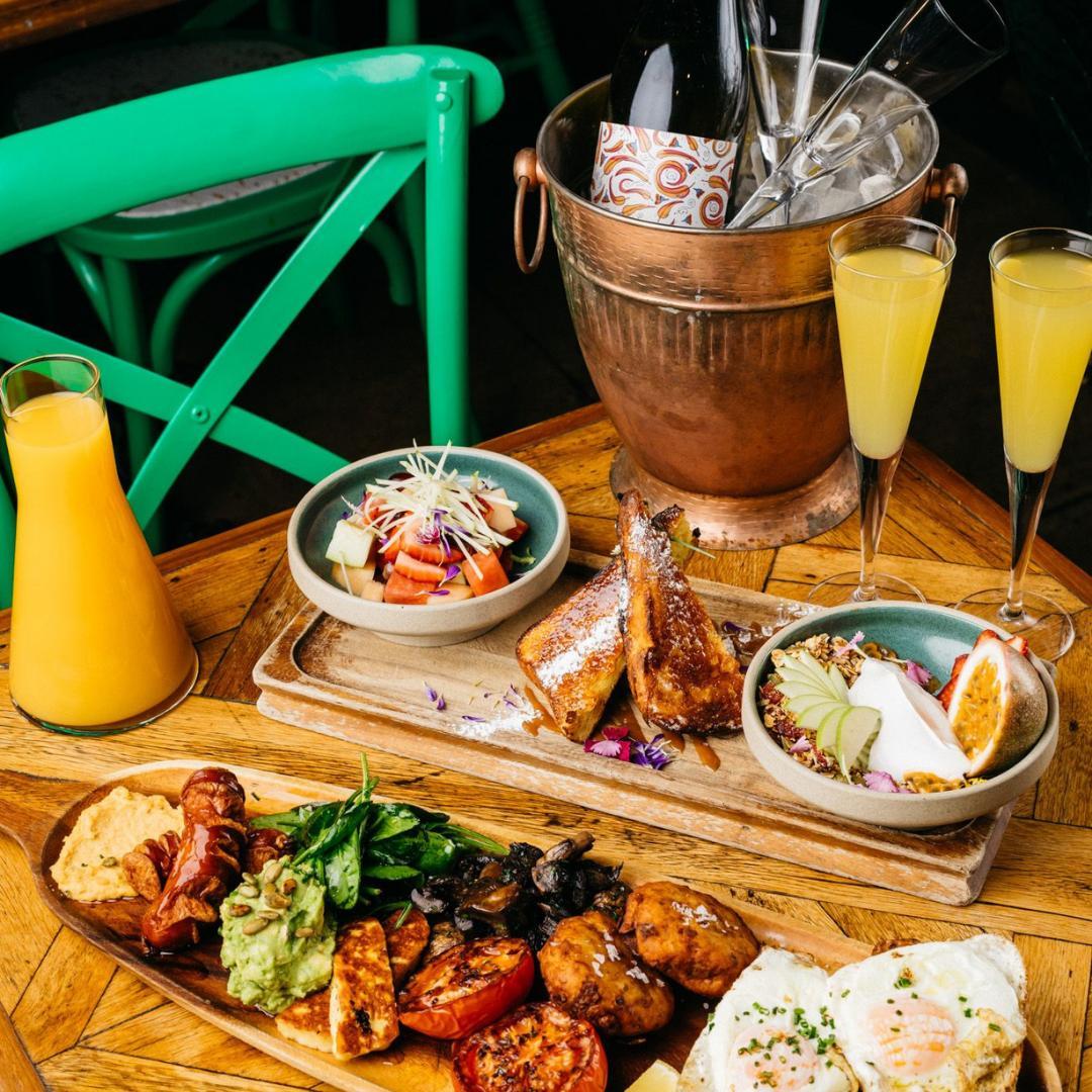 cocktails and breakfast dishes arrayed on a table