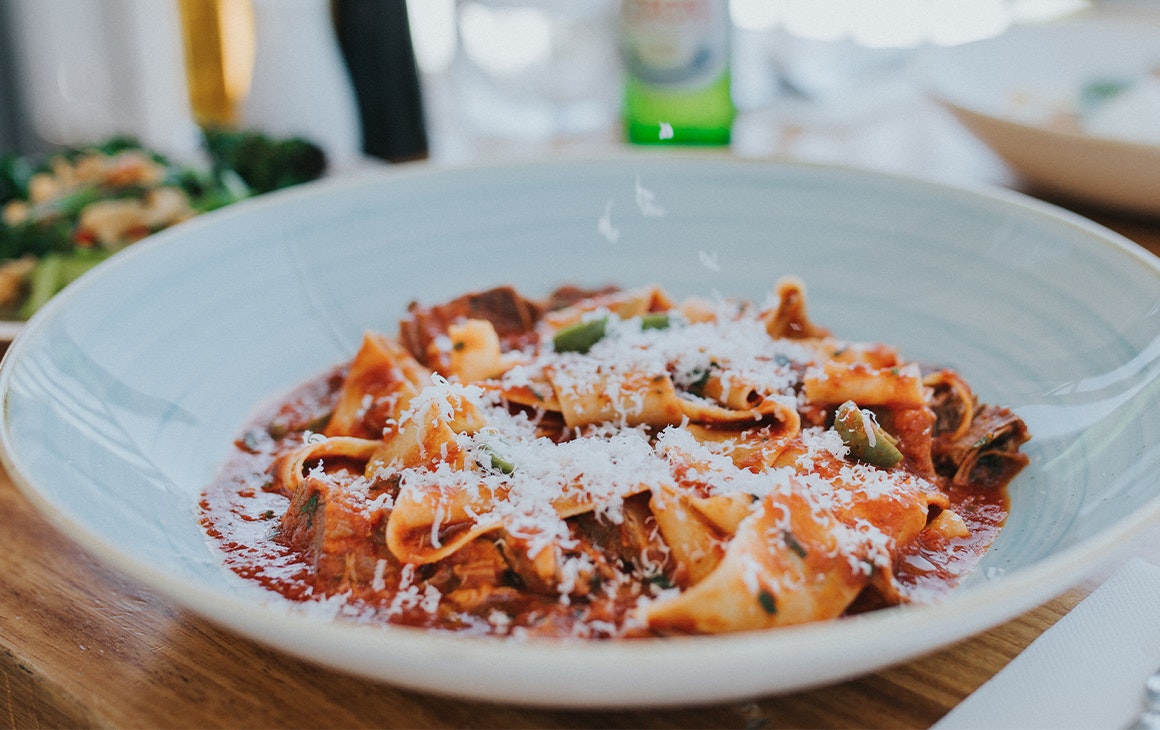 A bowl of pasta topped with parmesan