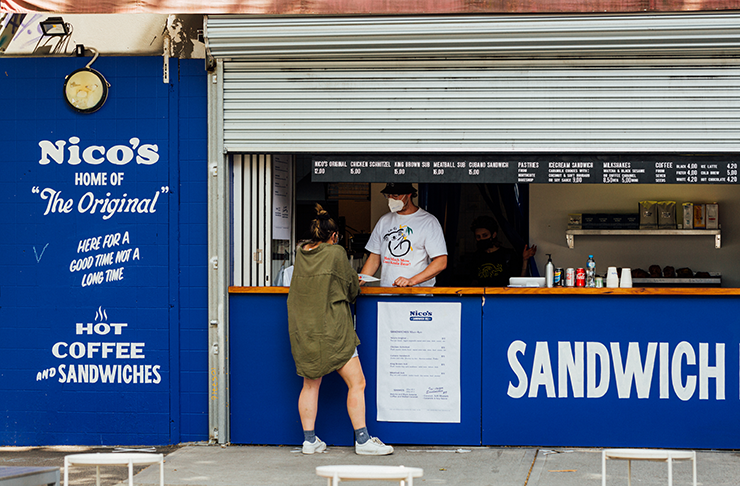 A sandwich store behind a roller door, painted royal blue.
