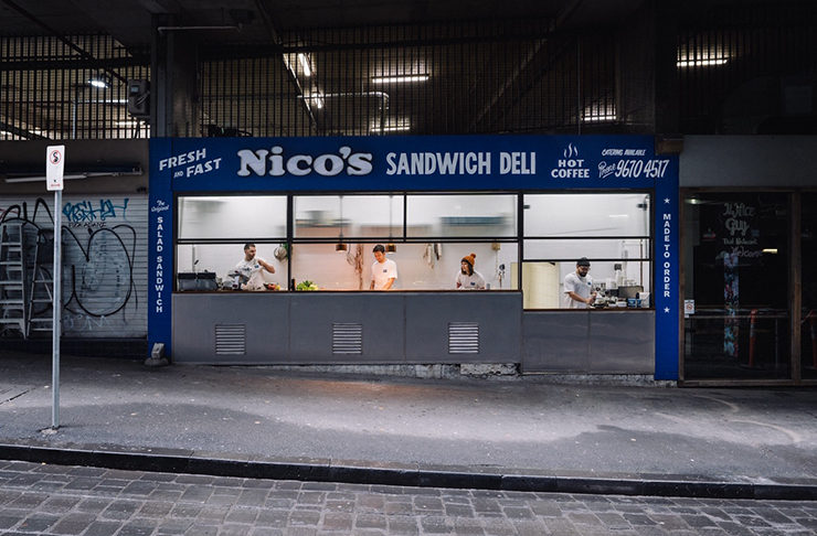 The blue exterior of a sandwich shop with old-school text reading 
