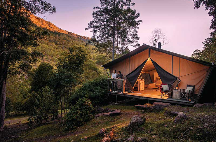 a luxe glamping tent outdoors at sunset
