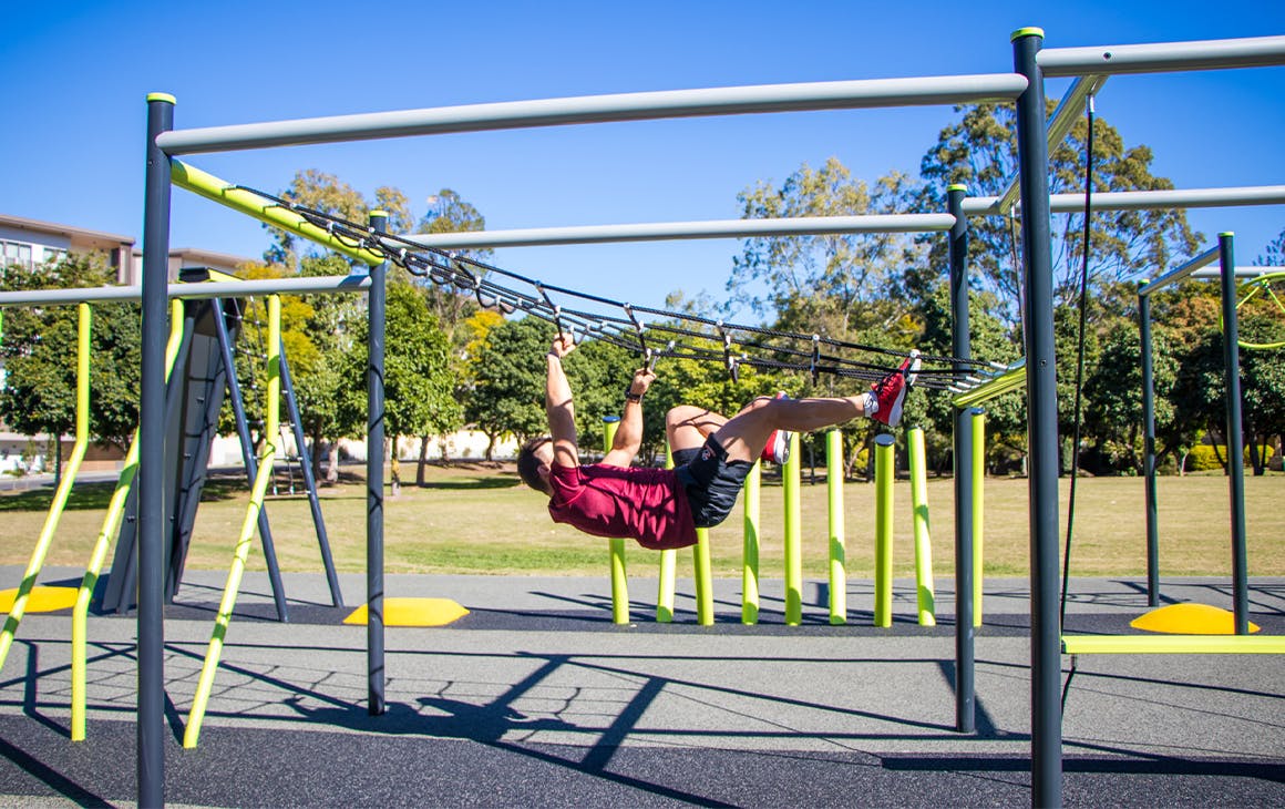 a man climbing a across a rope ladder upside down