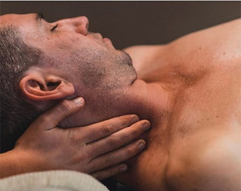 a man on a massage table getting his neck massaged
