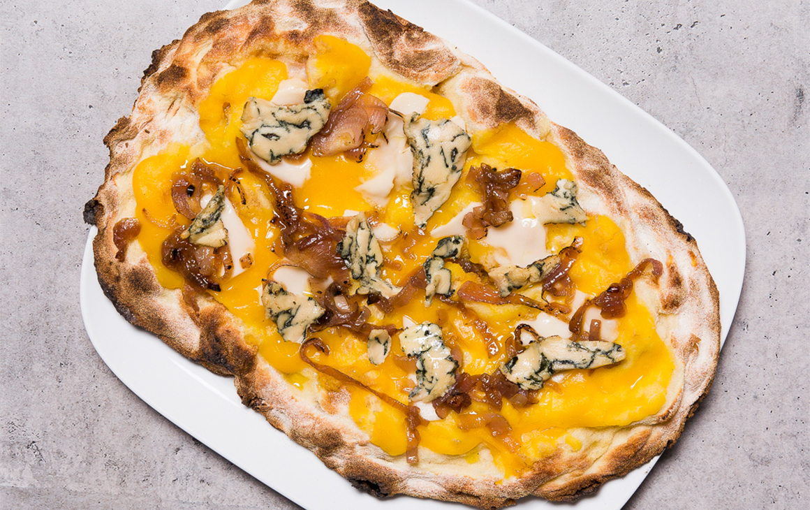 Pizza topped with blue cheese and pumpkin sauce