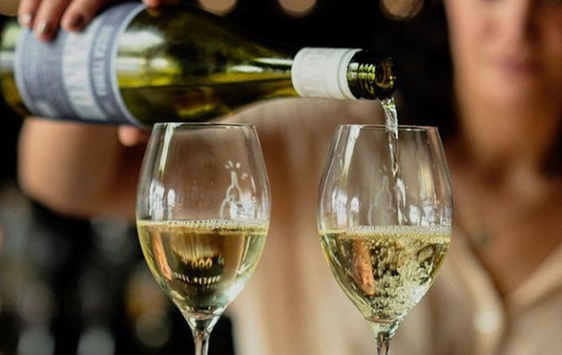 two glasses of white wine being poured at Northbird