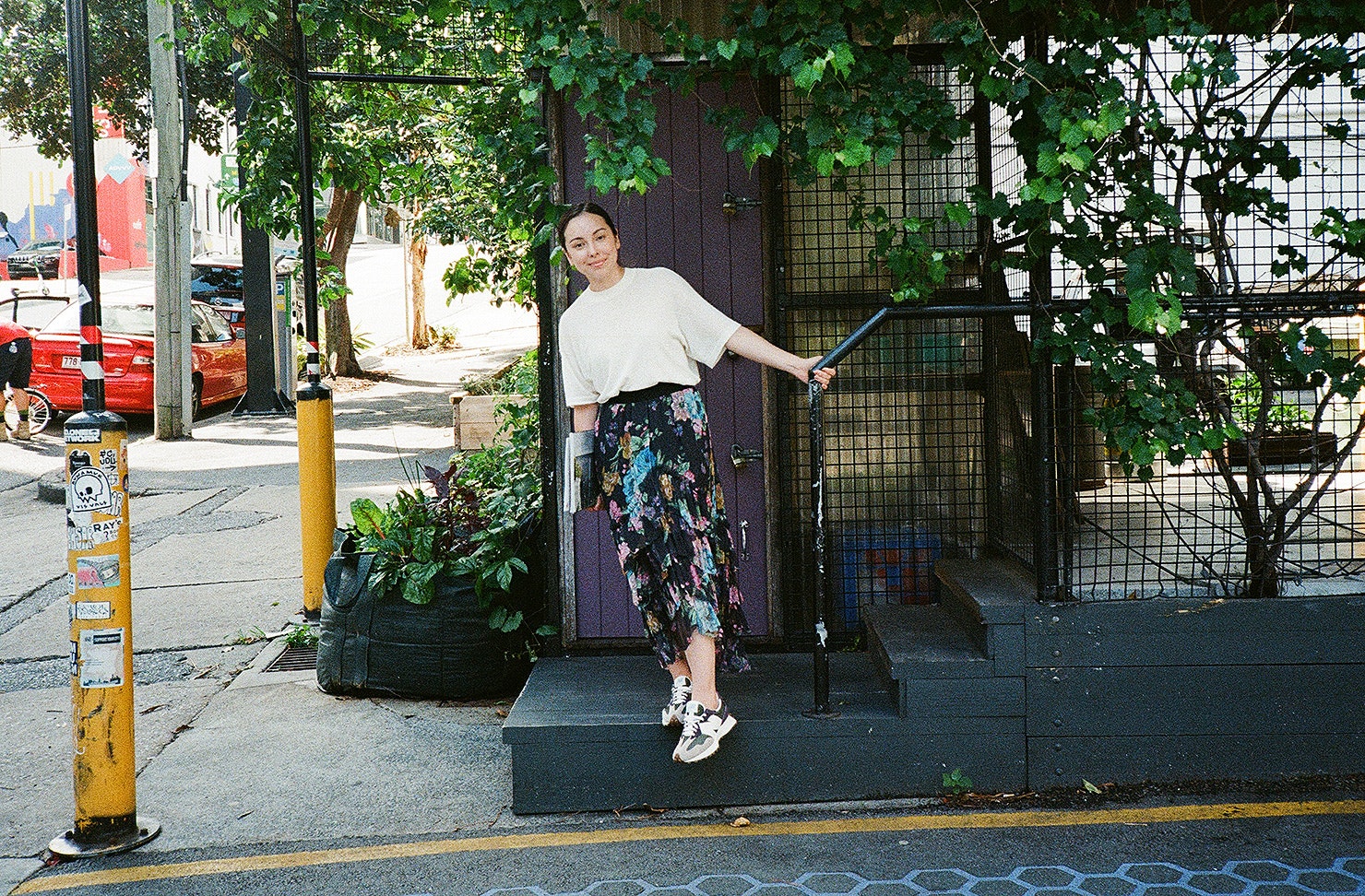 Someone stands outside a leafy office.