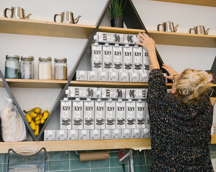 barista reaching for oatly carton