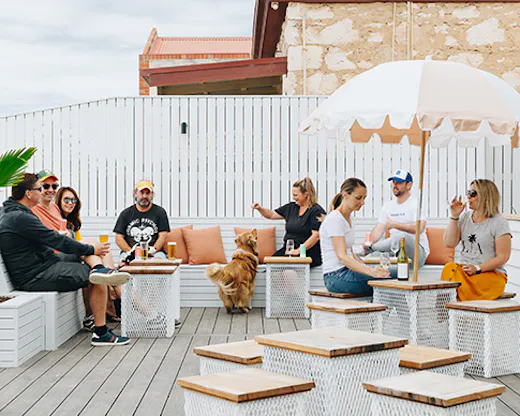 Several people sitting on a breezy outdoor courtyard.