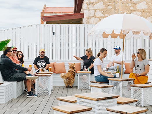 Several people sitting on a breezy outdoor courtyard.