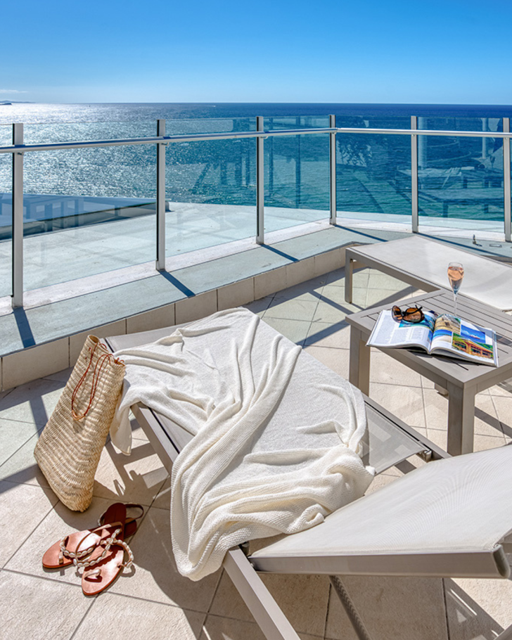 a sun-lounger on a balcony overlooking the ocean