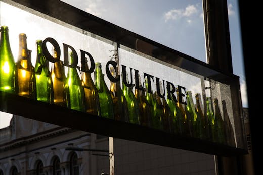 A shop sign for Odd Culture in Newtown, made with empty wine bottles.
