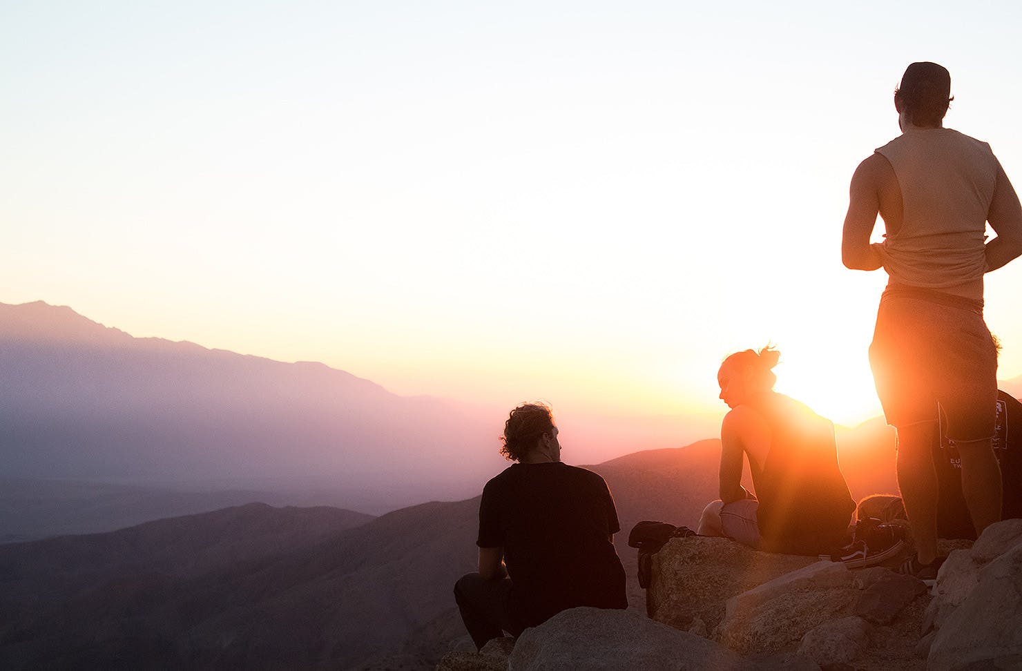Men stand on a hill chilling.