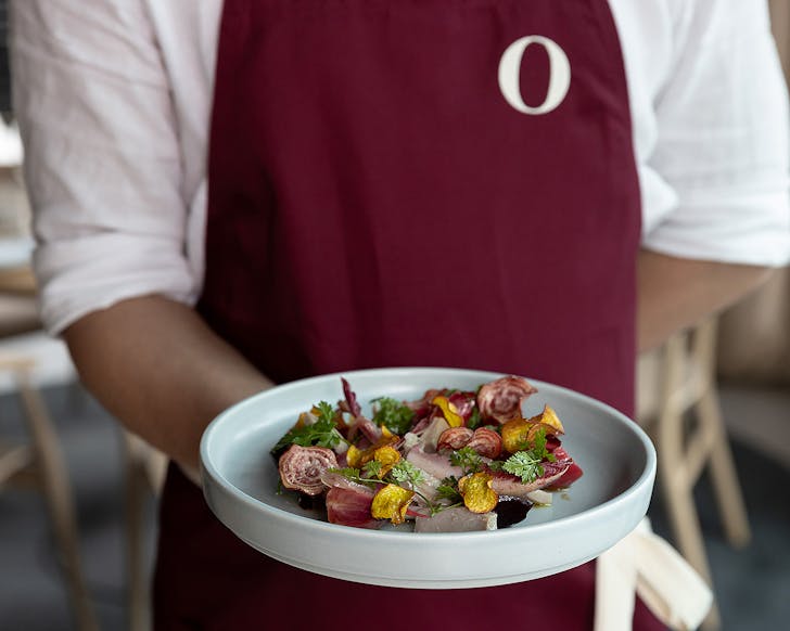 A man presents a delicious looking dish.