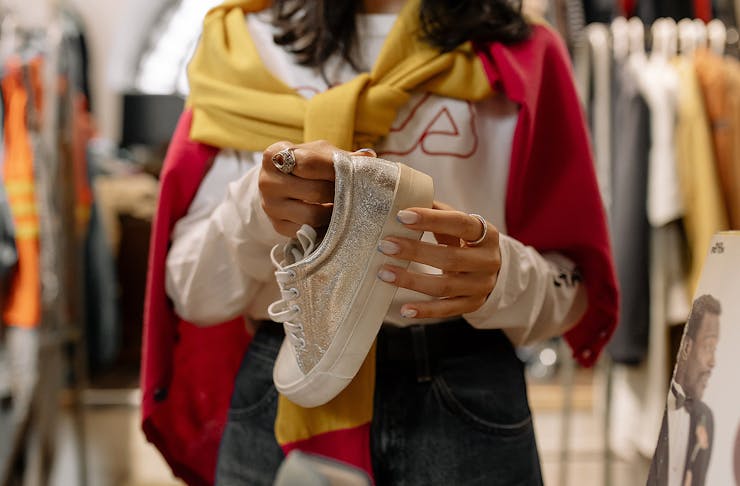 A person holds a sneaker to try on in a shop.