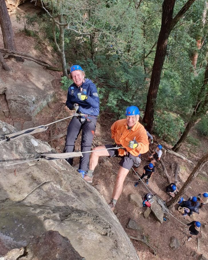 Two men abseil down a cliff face with Out and About Adventures Lake Macquarie