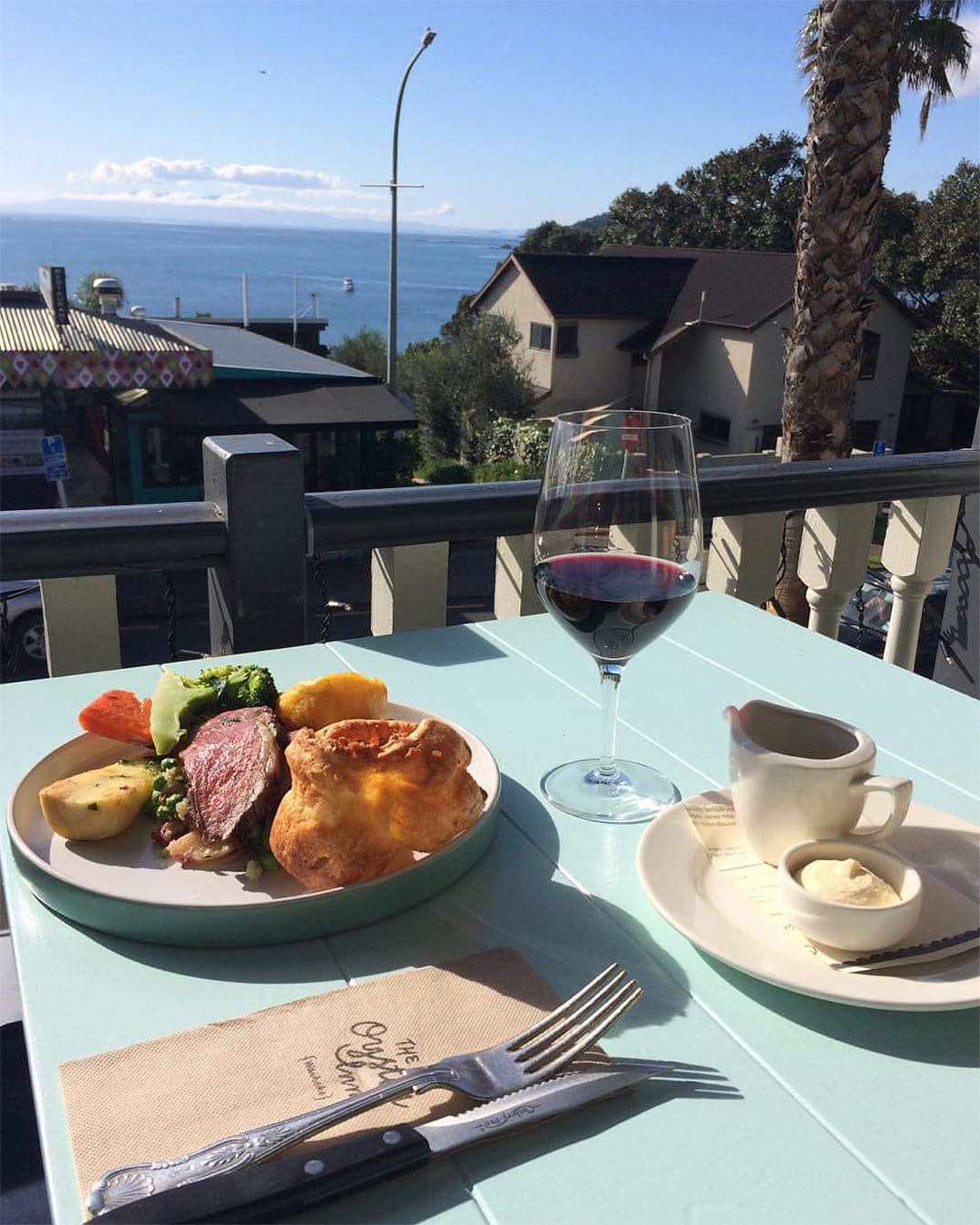 Oyster Inn's roast sits on a table overlooking the sea in Waiheke, one of Auckland's best roasts.