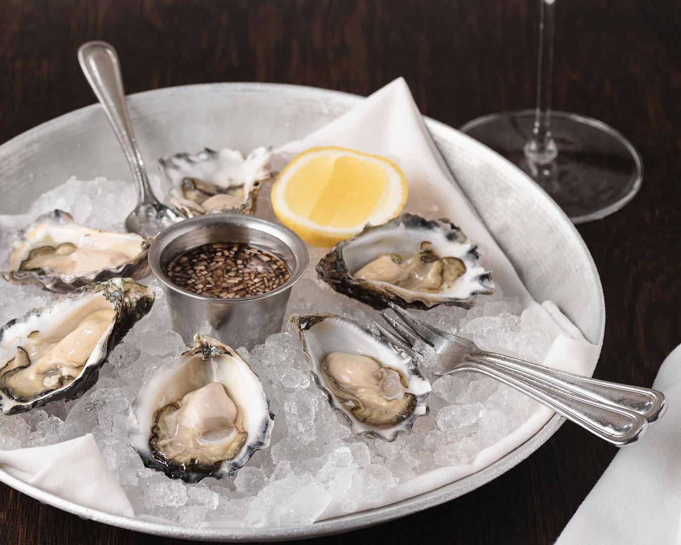 Plate of half-dozen oysters with lemon wedge