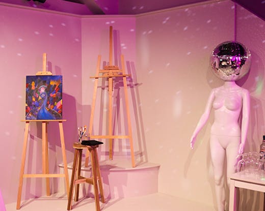 three easels and a model with a disco head