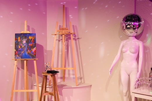 three easels and a model with a disco head