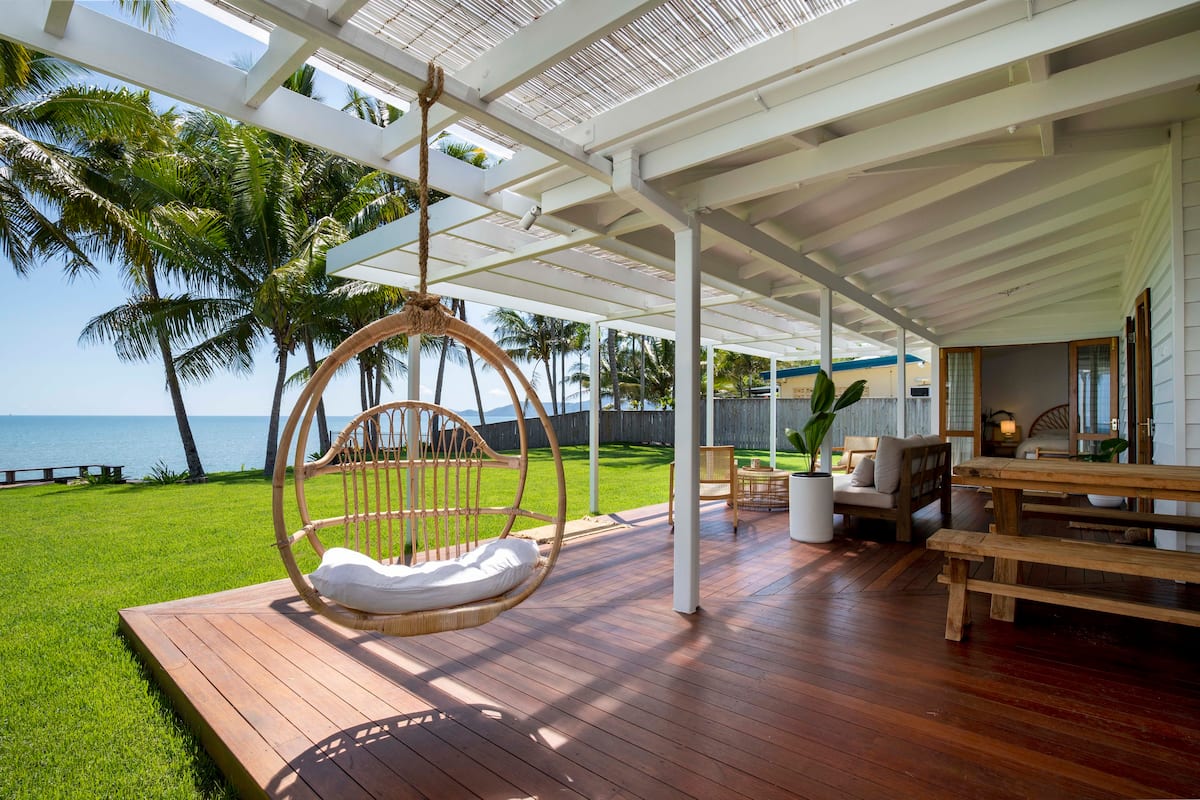 a deck facing out to a green yard on a beach