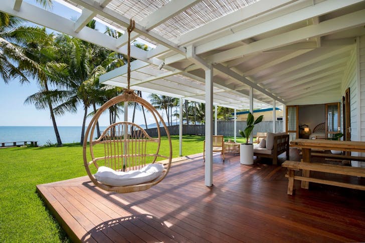 a deck facing out to a green yard on a beach