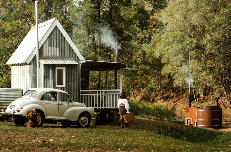 A tiny house with a hot tub in front of it