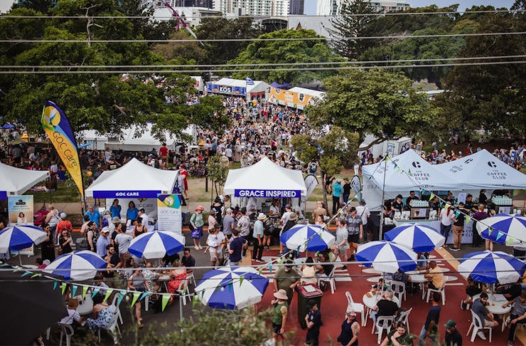 a festival with blue striped umbrellas and pop up tents