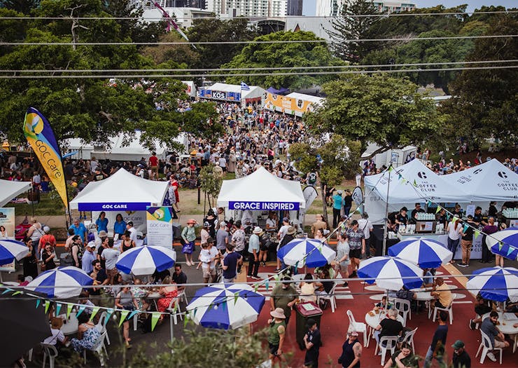 a festival with blue striped umbrellas and pop up tents