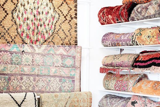 A beautiful collection of hanging and folded vintage Moroccan rugs.