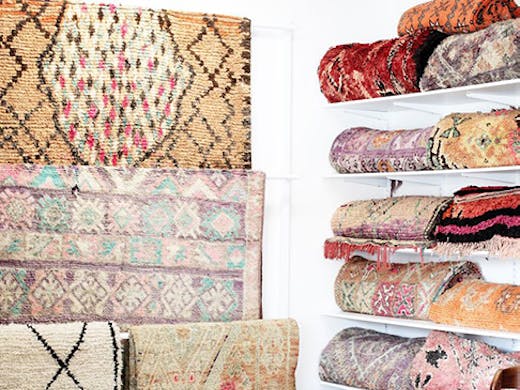 A beautiful collection of hanging and folded vintage Moroccan rugs.