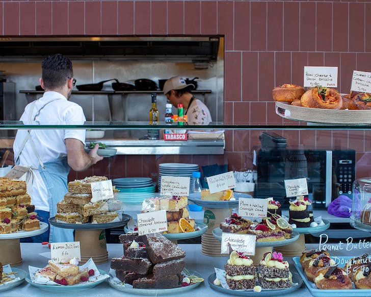 The busy kitchen at Patch with delicious cabinet food on display in the foreground.