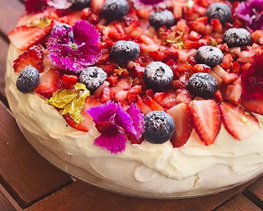 A fresh-made pavlova covered in berries.