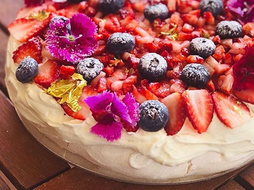 A fresh-made pavlova covered in berries.