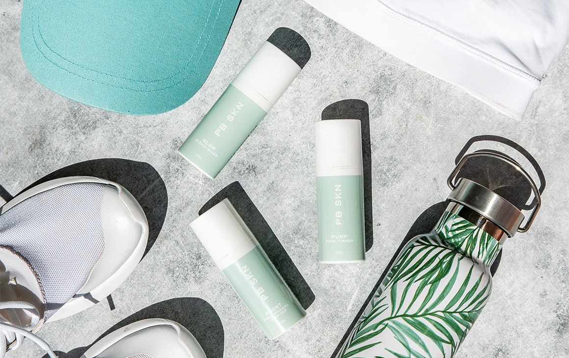 3 bottles of skincare with a waterbottle and sneakers