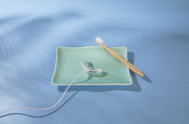 The Pearlii Teeth Whitening Kit on a green ceramic tray. 