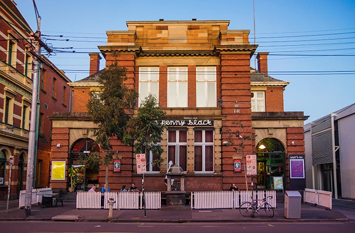 A large old-school pub towering in the sunset.
