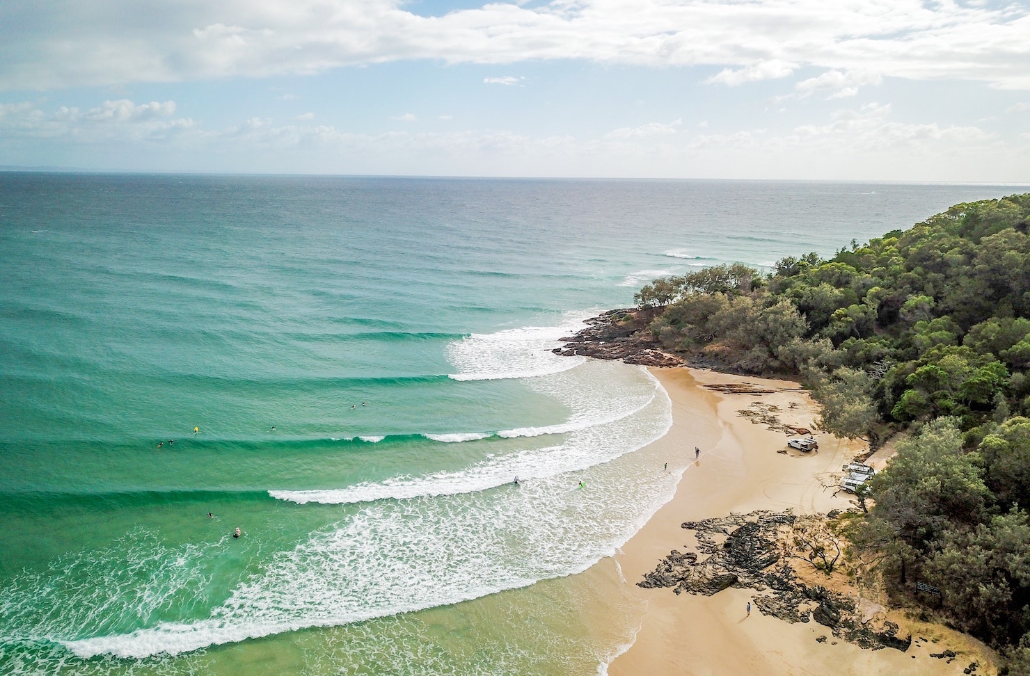 A small beach next to the forest with small campsites