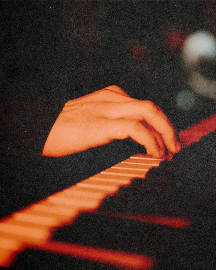 Close-up shot of a hand on a keyboard in a warm, orange-suffused room.