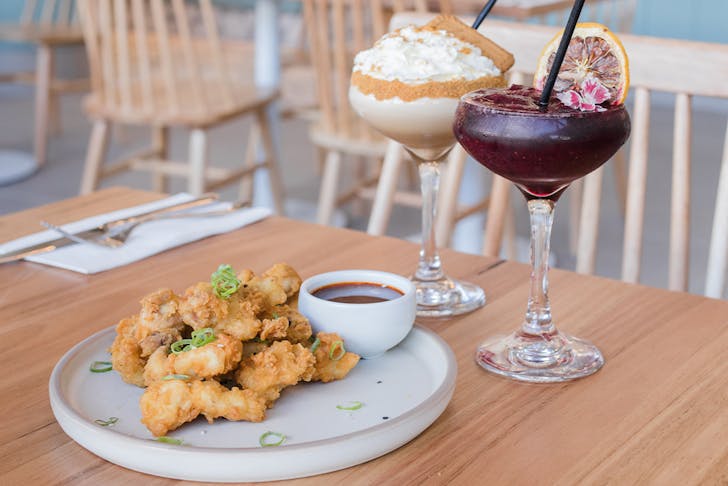 a plate of karaage chicken and two cocktails