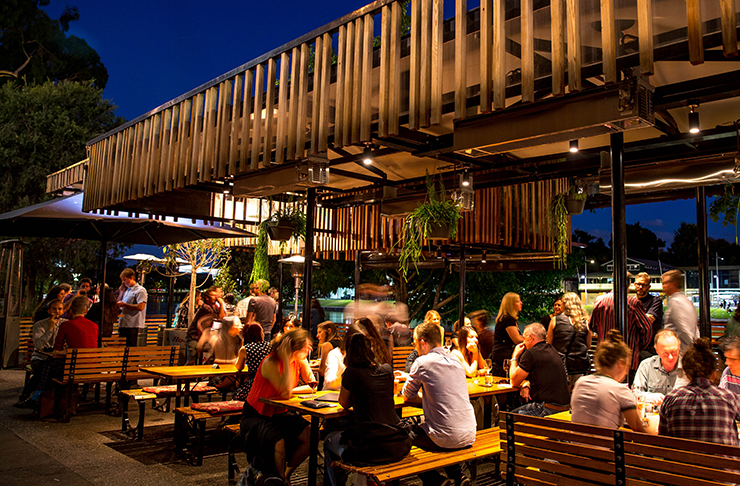 A bar lit up at night time by the Yarra River.