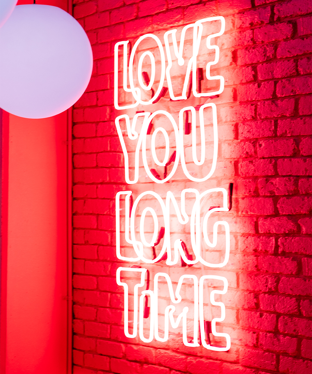a neon sign saying 'love you long time'