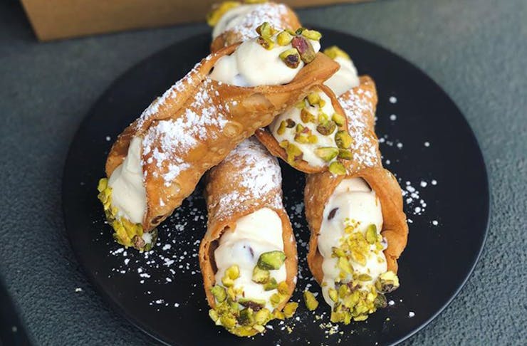 Several cannoli stacked on a plate