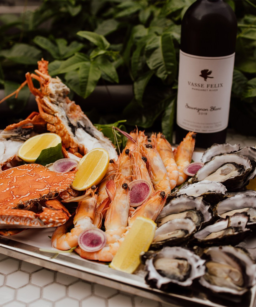 Platter of oysters and prawns with bottle of wine