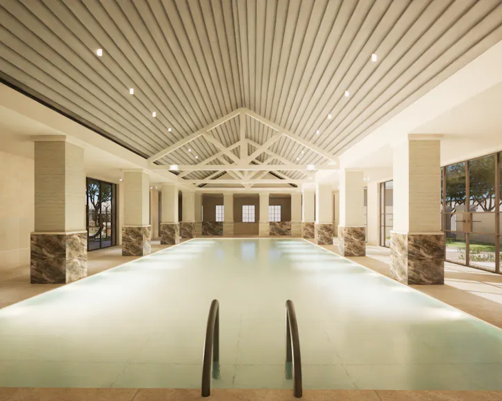 Render of AURA Spa & Bathhouse's indoor mineral pool, featuring soaring timber-lined ceilings, marble-clad columns, natural light and a serene resort-style setting.