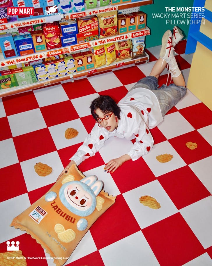 Image from Pop Mart Australia's Instagram of a woman model playfully laying on the floor holding a giant Labubu package. 