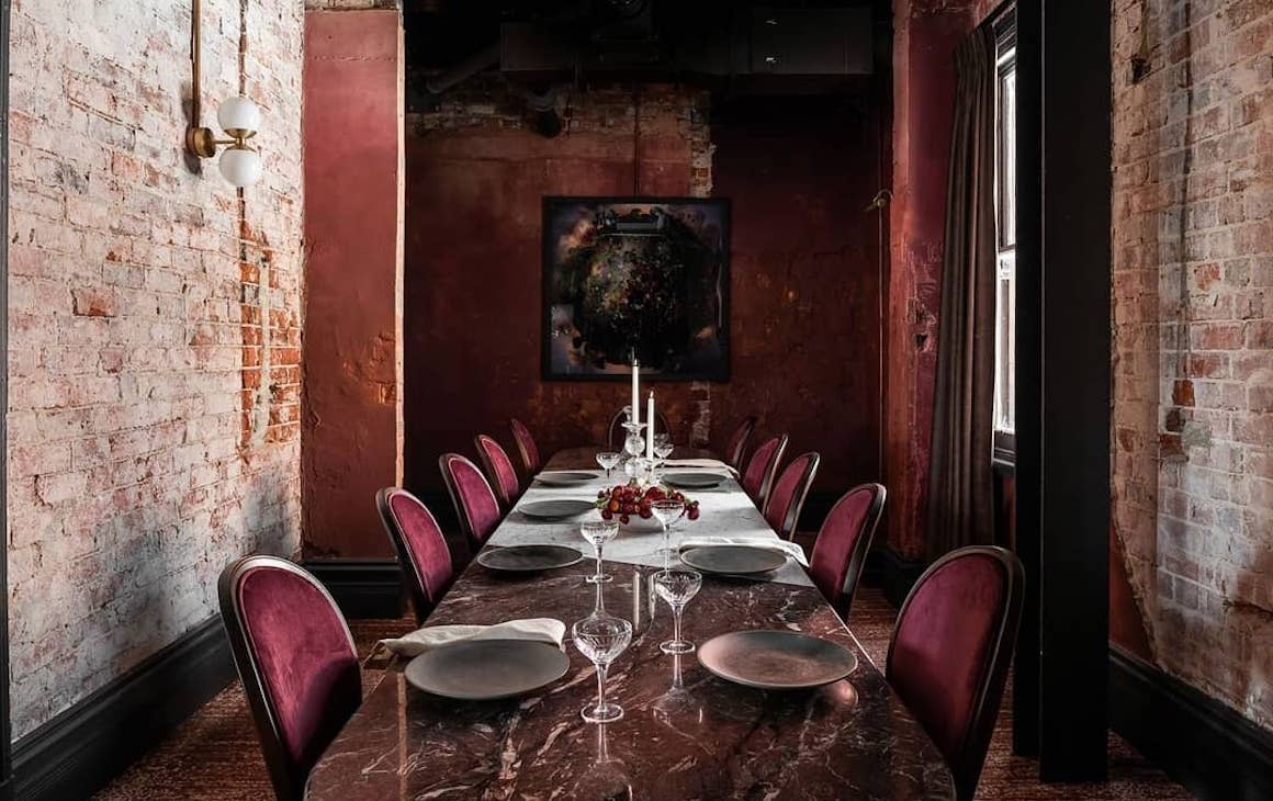 a red marble table in a private dining room at fleur