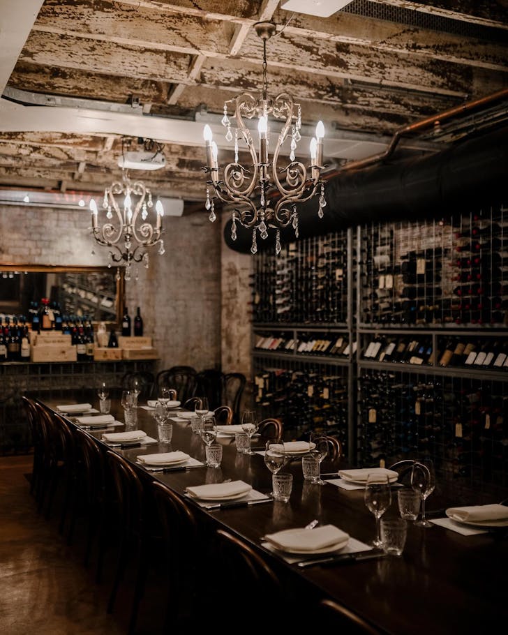 a room with a long table lined with wine bottles