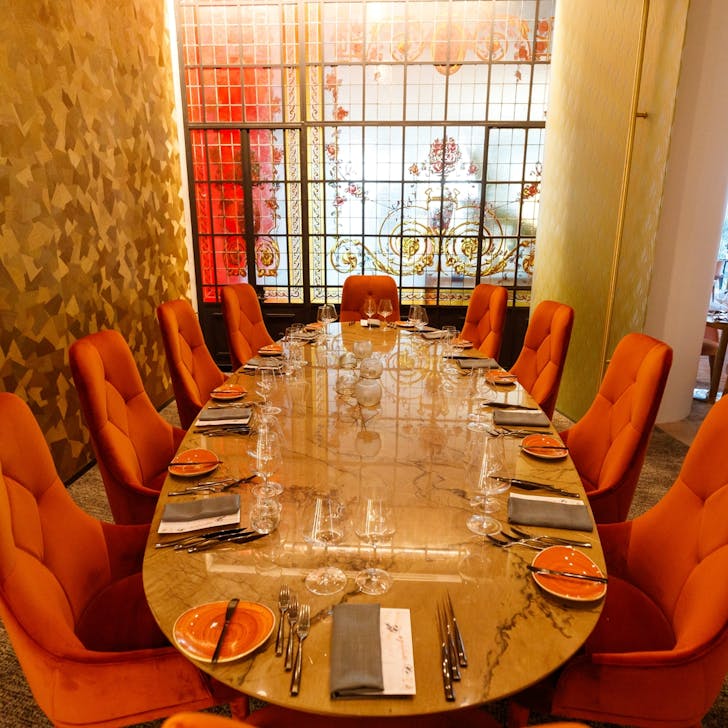 a room with a stained glass window and a large round dining table