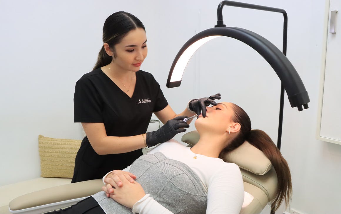 a beauty technician injecting a patient in the chin