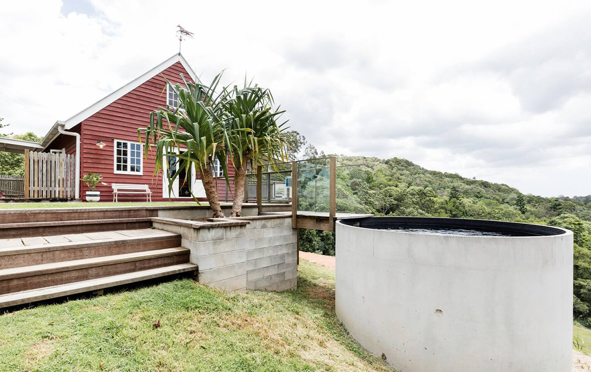 A bright red barn cottage, with a small pool out the front.